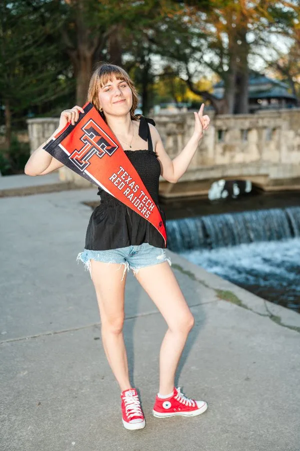 Senior holding a school pennant